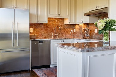 Example of a large classic u-shaped dark wood floor and brown floor enclosed kitchen design in Toronto with an undermount sink, recessed-panel cabinets, white cabinets, marble countertops, beige backsplash, stone slab backsplash, stainless steel appliances and a peninsula