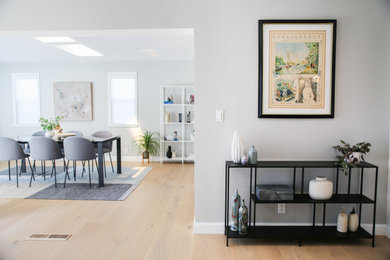 Example of a mid-sized minimalist light wood floor great room design in San Francisco with gray walls and no fireplace