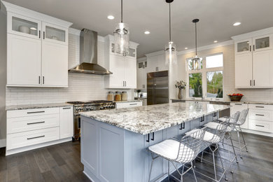 Inspiration for a contemporary medium tone wood floor and brown floor kitchen remodel in Jacksonville with a single-bowl sink, shaker cabinets, white cabinets, marble countertops, white backsplash, subway tile backsplash, stainless steel appliances, an island and multicolored countertops