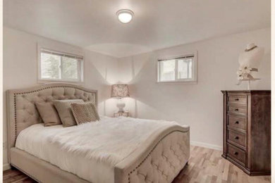 Ejemplo de dormitorio principal minimalista de tamaño medio con paredes beige y suelo marrón