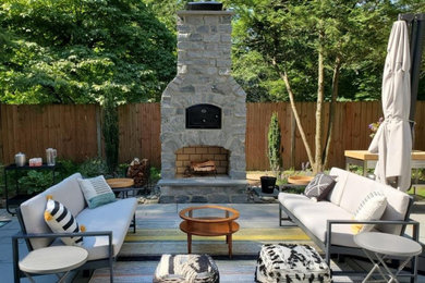 Modelo de patio tradicional renovado grande en patio trasero con chimenea y adoquines de piedra natural