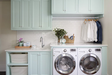 Mid-sized elegant single-wall dark wood floor and brown floor dedicated laundry room photo in Nashville with an undermount sink, quartz countertops, a side-by-side washer/dryer, white countertops, recessed-panel cabinets and beige walls