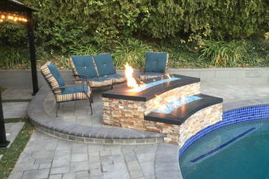 Inspiration for a mid-sized contemporary backyard patio in Los Angeles with a fire feature, concrete pavers and a gazebo/cabana.