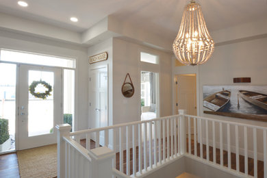 Entryway - large coastal medium tone wood floor and brown floor entryway idea in Edmonton with white walls and a white front door