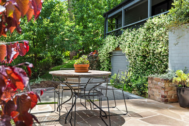 Inspiration for a contemporary front yard patio in Sydney with natural stone pavers.