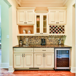 アトランタの小さいトラディショナルスタイルのおしゃれなウェットバー (アンダーカウンターシンク、レイズドパネル扉のキャビネット、白いキャビネット、御影石カウンター、マルチカラーのキッチンパネル、モザイクタイルのキッチンパネル、淡色無垢フローリング、茶色い床) の写真