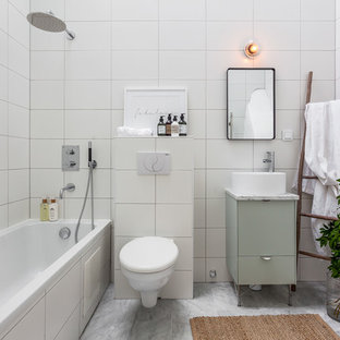 Foto di una stanza da bagno padronale scandinava di medie dimensioni con ante lisce, ante verdi, vasca da incasso, vasca/doccia, WC sospeso, piastrelle bianche, lavabo a bacinella, pareti bianche, pavimento in marmo e doccia aperta