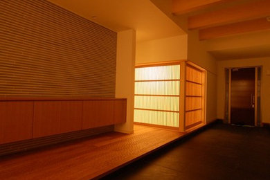 Modelo de hall asiático grande con paredes blancas, suelo de madera en tonos medios, puerta simple, puerta de madera en tonos medios y suelo beige
