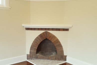 Photo of a mid-sized traditional master bedroom in Newcastle - Maitland with beige walls and a brick fireplace surround.