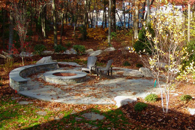 Example of a mid-sized mountain style backyard stone patio design in Providence with a fire pit