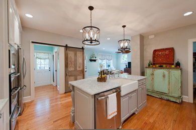 Eat-in kitchen - mid-sized cottage galley medium tone wood floor eat-in kitchen idea in Richmond with a farmhouse sink, raised-panel cabinets, light wood cabinets, granite countertops and an island