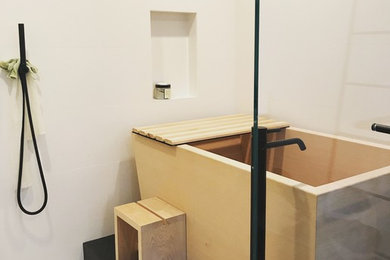 Photo of a mid-sized asian master wet room bathroom in San Francisco with flat-panel cabinets, dark wood cabinets, white tile, concrete benchtops, white benchtops, a japanese tub, a one-piece toilet, white walls, pebble tile floors, an integrated sink, beige floor and an open shower.