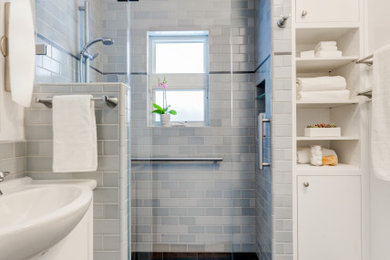 Example of a small transitional blue tile and ceramic tile porcelain tile, blue floor and single-sink bathroom design in San Francisco with flat-panel cabinets, white cabinets, a wall-mount toilet, white walls, an integrated sink, solid surface countertops, white countertops, a niche and a built-in vanity