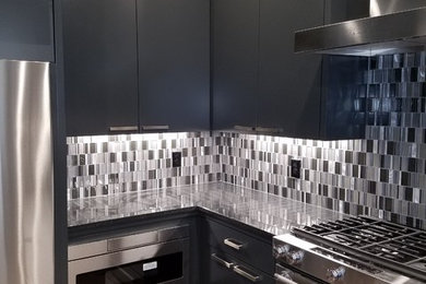 Inspiration for a small modern l-shaped eat-in kitchen remodel in Dallas with black cabinets, multicolored backsplash, stainless steel appliances, no island and black countertops