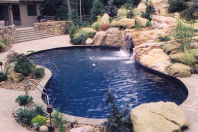Inspiration for a mid-sized timeless backyard concrete paver and custom-shaped pool fountain remodel in Cleveland