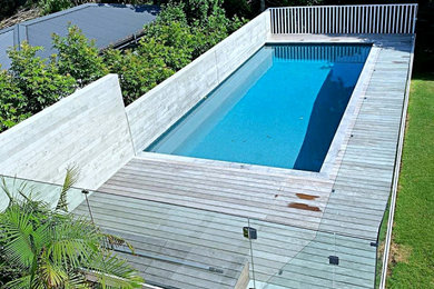 Diseño de piscina natural costera de tamaño medio a medida en patio trasero con privacidad y entablado