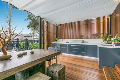 Inspiration for a large modern backyard deck in Melbourne with an outdoor kitchen and a roof extension.