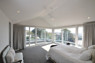 Mid-sized contemporary guest bedroom in Sydney with white walls, carpet and grey floor.