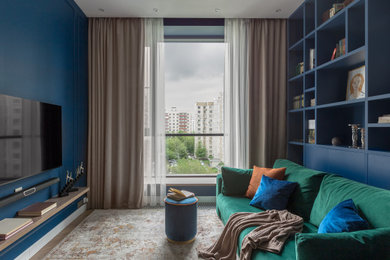 Aménagement d'une petite salle de séjour contemporaine fermée avec un mur bleu, un sol en bois brun, un téléviseur fixé au mur et un sol beige.