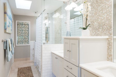 Photo of a mid-sized transitional master bathroom in Austin with shaker cabinets, white cabinets, an alcove shower, beige tile, white tile, mosaic tile, beige walls, marble floors, an undermount sink, solid surface benchtops, an alcove tub, a two-piece toilet, beige floor and a shower curtain.