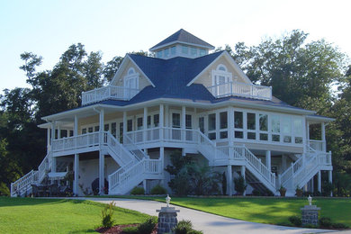 Large beach style two-storey beige exterior in Raleigh with wood siding.