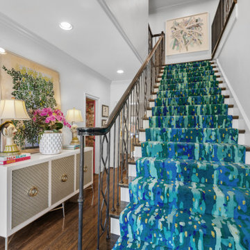 Vibrant Staircase with Bold Blue Runner and Artistic Décor