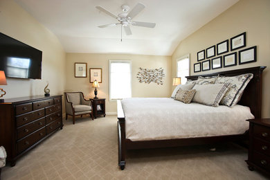 Elegant master carpeted bedroom photo in Milwaukee with beige walls