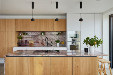 This is an example of a large contemporary single-wall open plan kitchen in London with an island.