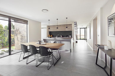 Photo of a mid-sized contemporary kitchen/dining combo in Canberra - Queanbeyan with beige walls, porcelain floors and grey floor.
