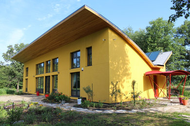 Mid-sized minimalist yellow one-story stucco house exterior photo in Chicago
