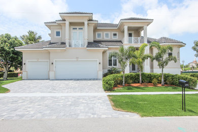 Mid-sized contemporary beige two-story stucco exterior home idea in Miami with a hip roof