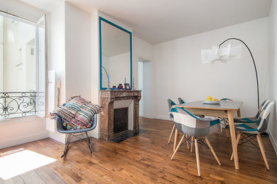 Cette image montre une salle de séjour nordique de taille moyenne et ouverte avec un mur blanc, parquet clair, une cheminée standard, un manteau de cheminée en pierre et un téléviseur dissimulé.