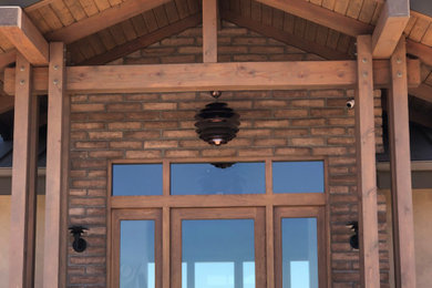 Inspiration for a mid-sized slate floor, exposed beam and brick wall entryway remodel in Santa Barbara with a medium wood front door