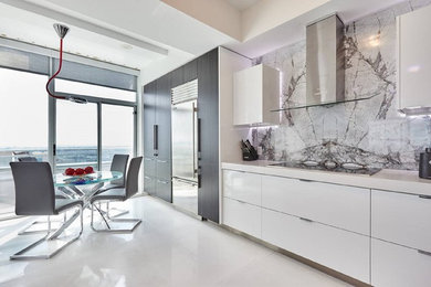 Open concept kitchen - mid-sized contemporary galley marble floor open concept kitchen idea in Toronto with a drop-in sink, flat-panel cabinets, white cabinets, marble countertops, gray backsplash, stone tile backsplash, stainless steel appliances and an island