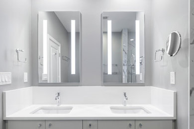 Photo of a large modern bathroom in DC Metro with flat-panel cabinets, grey cabinets, an alcove shower, a two-piece toilet, grey tiles, porcelain tiles, grey walls, porcelain flooring, a submerged sink, engineered stone worktops, grey floors, a hinged door, white worktops, a wall niche, double sinks and a built in vanity unit.