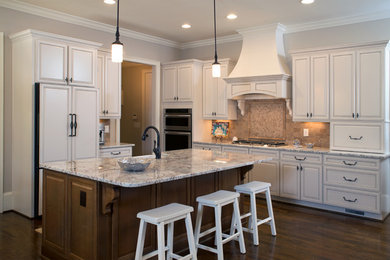 Inspiration for a traditional l-shaped kitchen in Atlanta with a farmhouse sink, raised-panel cabinets, white cabinets, granite benchtops and stainless steel appliances.