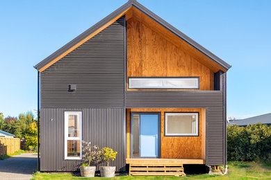 Inspiration for a small contemporary two-storey grey house exterior in Christchurch with metal siding and a gable roof.