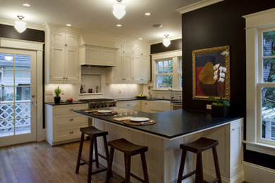 Example of a classic u-shaped kitchen design in Portland with a farmhouse sink, shaker cabinets, beige cabinets and subway tile backsplash