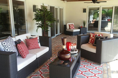 Example of a large transitional backyard brick patio design in Orlando with a roof extension