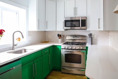 Modern inredning av ett litet vit vitt kök, med en undermonterad diskho, skåp i shakerstil, gröna skåp, bänkskiva i kvarts, vitt stänkskydd, stänkskydd i porslinskakel, rostfria vitvaror, mellanmörkt trägolv och en halv köksö