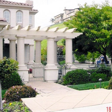 Jazzed up entry with wrought iron fencing and think columns supporting entry per