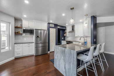 Example of a large minimalist single-wall porcelain tile and brown floor eat-in kitchen design in Phoenix with an undermount sink, shaker cabinets, white cabinets, quartz countertops, white backsplash, porcelain backsplash, stainless steel appliances, an island and multicolored countertops