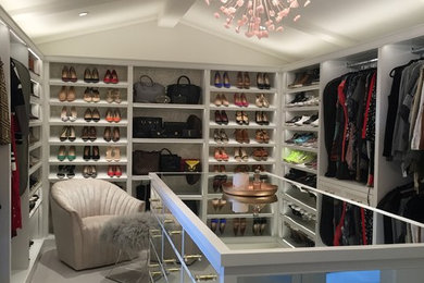 Large transitional women's carpeted and beige floor dressing room photo in Los Angeles with glass-front cabinets and white cabinets