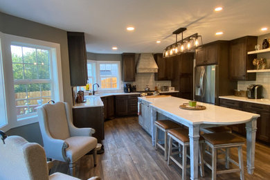 Inspiration for a large rustic u-shaped vinyl floor and multicolored floor open concept kitchen remodel in Portland with an undermount sink, recessed-panel cabinets, distressed cabinets, quartz countertops, gray backsplash, ceramic backsplash, stainless steel appliances, an island and white countertops