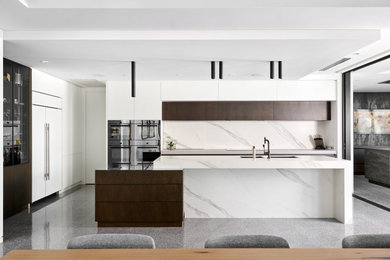Expansive contemporary l-shaped kitchen/diner in Perth with a submerged sink, flat-panel cabinets, white cabinets, engineered stone countertops, white splashback, porcelain splashback, black appliances, concrete flooring, an island, grey floors and white worktops.