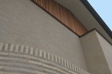 Réalisation d'une façade de maison beige asiatique à un étage.