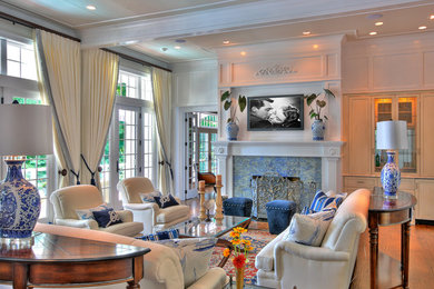 Mid-sized elegant enclosed and formal medium tone wood floor living room photo in New York with a standard fireplace, a stone fireplace, a wall-mounted tv and white walls