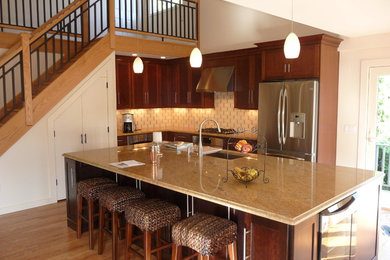 Eat-in kitchen - mid-sized transitional l-shaped light wood floor eat-in kitchen idea in New York with a drop-in sink, recessed-panel cabinets, dark wood cabinets, white backsplash, stainless steel appliances and an island