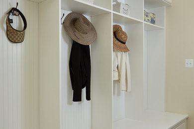 Example of a large classic travertine floor mudroom design in DC Metro with beige walls