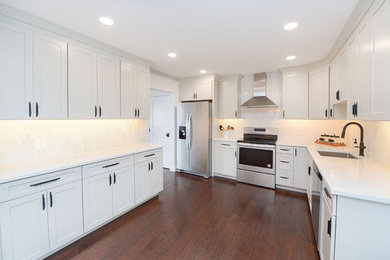 Eat-in kitchen - transitional u-shaped dark wood floor and brown floor eat-in kitchen idea in Philadelphia with a single-bowl sink, shaker cabinets, white cabinets, white backsplash, stainless steel appliances and white countertops